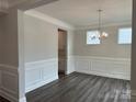 Elegant dining room with wood floors, wainscoting, and a stylish chandelier at 5103 Heathland Dr # 50, Charlotte, NC 28215