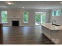 Bright living room featuring hardwood floors, a fireplace, and access to the outdoor patio at 5103 Heathland Dr # 50, Charlotte, NC 28215