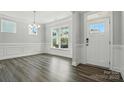 Living room with gray flooring, white walls, with crown moulding, and a front door at 5103 Heathland Dr # 50, Charlotte, NC 28215