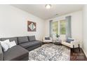 Bright living room with a gray couch, two chairs, patterned rug and plenty of natural light at 7113 Meridale Forest Dr, Charlotte, NC 28269