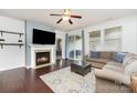 Cozy living room with a fireplace, ceiling fan, dark wood floors, and a sliding glass door at 7113 Meridale Forest Dr, Charlotte, NC 28269