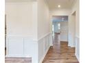 Bright hallway features wainscoting, hardwood floors, and views into adjacent rooms with a neutral color palette at 8286 Ashvale Nw St, Concord, NC 28027