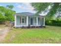 Charming home with light blue siding, a cozy screened-in porch, and a well-maintained yard at 917 Laye St, Belmont, NC 28012
