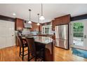 Modern kitchen features stainless steel appliances, wood cabinetry, granite counters, and hardwood floors at 920 Habersham Dr, Charlotte, NC 28209