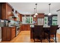 Well-equipped kitchen with stainless appliances, dark wood cabinets, granite countertops, and hardwood floors at 920 Habersham Dr, Charlotte, NC 28209