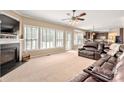 Cozy living room featuring plush leather seating, fireplace, and natural light at 100 Oakwood Meadow Dr, Mooresville, NC 28115