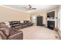 Inviting living room with a dark leather sofa, fireplace, and lots of space for living at 100 Oakwood Meadow Dr, Mooresville, NC 28115