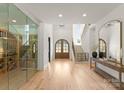 Grand foyer with hardwood floors, staircase, and a glass-enclosed wine cellar at 10201 Laurier Ln, Huntersville, NC 28078