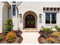 Close-up of the arched double front door, flanked by elegant lanterns and lush landscaping at 10201 Laurier Ln, Huntersville, NC 28078