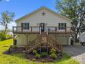 Inviting two-story home featuring a spacious wooden deck, manicured landscaping, and a convenient garage at 1077 Jackson Rd, Fort Lawn, SC 29714
