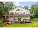 Spacious home showcasing a large wooden deck, boat storage, and serene surroundings at 1077 Jackson Rd, Fort Lawn, SC 29714