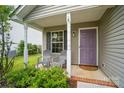 Inviting front porch with seating, a purple front door, and stylish fixtures at 1162 Willet Dr, Rock Hill, SC 29732