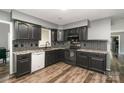 Modern kitchen with black cabinetry, stainless steel appliances, granite countertops, and tile backsplash at 131 Scotland Dr, Mooresville, NC 28115
