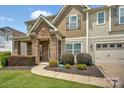 Charming home boasts a stone facade, covered porch, manicured lawn, and attached garage at 14837 Dungannon Ct, Charlotte, NC 28278