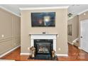 Cozy living area with fireplace, mounted television, and classic trim details at 14837 Dungannon Ct, Charlotte, NC 28278