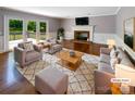 Bright living room with hardwood floors, fireplace, and French doors leading to outdoor deck at 1507 Chadmore Nw Ln, Concord, NC 28027