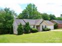 Inviting single-story home with a lush green lawn and mature trees, complete with attached garage at 1657 6Th Se St, Hickory, NC 28602