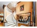 Elegant foyer featuring a sweeping staircase, chandelier, and dining room entrance at 1720 Mills Harris Rd, Wingate, NC 28174