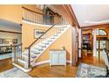 Elegant foyer featuring a curved staircase, hardwood floors, and detailed trim work at 1720 Mills Harris Rd, Wingate, NC 28174