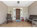 Inviting front porch with wooden bench, rocking chair, and flower pot at 17501 Youngblood Rd, Charlotte, NC 28278