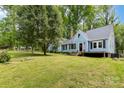 Beautiful light-blue home boasts lush green lawn and a picturesque setting surrounded by mature trees at 200 Cleveland Ave, Shelby, NC 28150