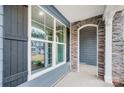 Inviting covered porch with stone accents, showcasing a window and elegant architectural details at 2011 Cedar Falls Dr # 71, Waxhaw, NC 28173