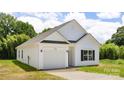 Well-maintained home featuring a white exterior, an attached garage, and a lush green yard at 220 S Columbia St, Gastonia, NC 28054