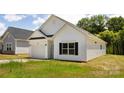 Side view of a well-kept home with green grass and a gray house to the left at 220 S Columbia St, Gastonia, NC 28054
