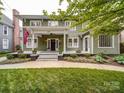 Charming green house with a welcoming front porch and a neatly manicured lawn at 226 Union S St, Concord, NC 28025