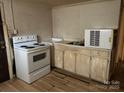 Kitchen with dated appliances, including an electric range, and worn cabinetry at 2703 E Greenbriar Rd, Statesville, NC 28625