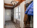 Stylish entryway with a brick accent wall, wooden beams, and tile flooring at 303 Island Ford Rd, Maiden, NC 28650