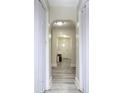 Inviting hallway features arched doorways, modern gray flooring, and fresh, neutral paint throughout at 303 Island Ford Rd, Maiden, NC 28650