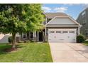 Charming two-story home featuring a well-manicured lawn, attached garage, and beautiful stone accents at 4324 Falls Lake Sw Dr, Concord, NC 28025