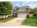 Beautiful two-story home featuring a well-manicured lawn, attached garage, and lovely stone accents at 4324 Falls Lake Sw Dr, Concord, NC 28025