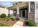Inviting front porch with stone pillars, a dark front door, and manicured landscaping at 4324 Falls Lake Sw Dr, Concord, NC 28025