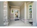Covered front porch with stone accents and a view of the landscaped front yard at 5028 Polo Gate Blvd, Charlotte, NC 28216