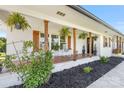 Inviting covered front porch with white brick, wooden columns and hanging plants at 5710 Lander Benton Rd, Unionville, NC 28110
