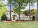 Charming painted brick home with mature trees in the front yard, complemented by manicured landscaping and a welcoming entrance at 5822 Alexa Rd, Charlotte, NC 28277