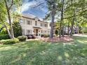 Beautiful painted brick two-story home with a manicured lawn and well-maintained landscaping, framed by mature trees and greenery at 5822 Alexa Rd, Charlotte, NC 28277
