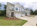 Shot of modern townhomes with well-maintained lawns and attached garages on a cloudy day at 8221 Houser St, Cornelius, NC 28031
