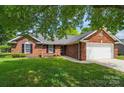 Beautiful brick home with lush lawn, trimmed shrubs, and a spacious two-car garage at 8309 Emily Dr, Harrisburg, NC 28075