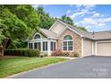 Beautiful exterior showcasing stone and siding, arched windows, and well-kept landscaping at 9013 Trellis Pointe Blvd, Charlotte, NC 28227