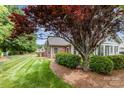Landscaped yard with a well-maintained lawn and mature trees surrounding the home's exterior at 9013 Trellis Pointe Blvd, Charlotte, NC 28227