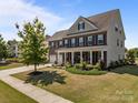 Beautiful brick two-story home with a covered front porch and well-manicured landscaping at 9871 Travertine Trl, Davidson, NC 28036