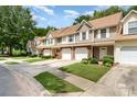 Exterior view of townhomes with well-maintained lawns and driveways in a residential area on a sunny day at 10421 Columbia Crest Ct, Charlotte, NC 28270