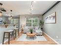 Bright living room featuring hardwood floors, a cozy sofa, and a view through the large window at 10421 Columbia Crest Ct, Charlotte, NC 28270