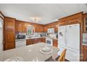Well-lit kitchen with wood cabinets, white appliances, granite countertops, and a breakfast bar at 105 Carrie Ln # 3, Cherryville, NC 28021