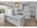 Bright kitchen with white cabinetry, a large island with a sink, pendant lights, and stainless steel appliances at 114 Wilharr Ct # 38, Mooresville, NC 28115