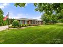 Beautifully landscaped front yard with lush green lawn and mature trees framing the brick home at 12117 Idlewild Rd, Matthews, NC 28105