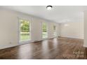 Spacious living room with hardwood floors and multiple windows providing ample natural light at 12117 Idlewild Rd, Matthews, NC 28105